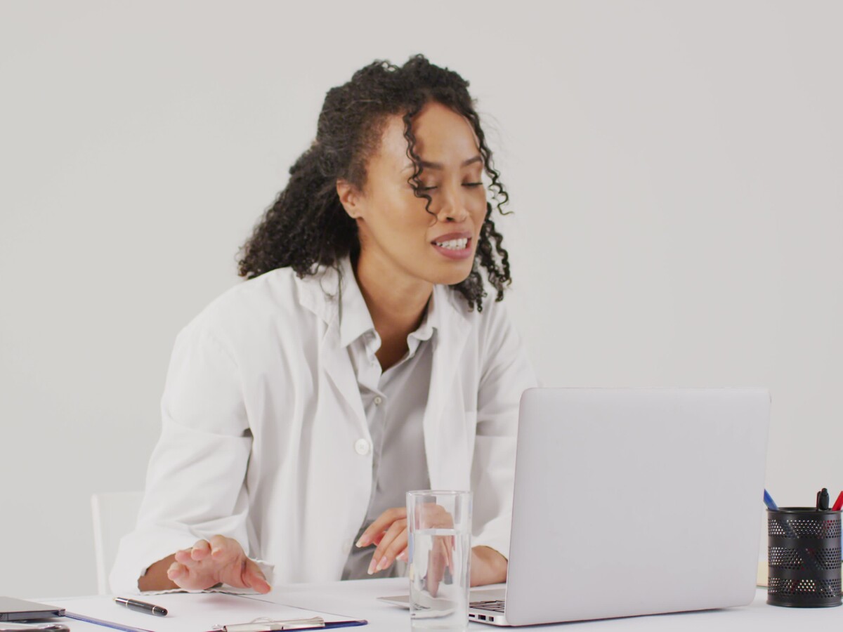 Smiling_Female_Doctor_on_Video_Call_with_Laptop_in_Office
