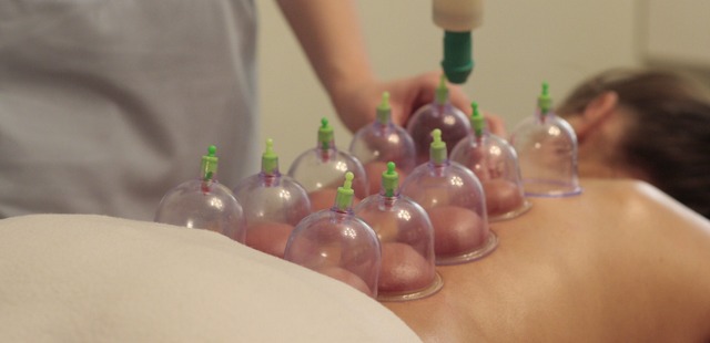 practitioner-doing-a-dry-cupping-on-a-females-back-while-she-is-lying-flat2 A matrix of plastic vacuum cups applied along a patient's back with a hand pump valve to perform clinical dry cupping for chronic back pain management