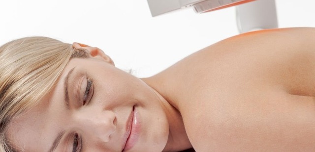 A relaxed female patient receiving infrared heat therapy essex to stimulate deep tissue repair and local microvascular circulation
